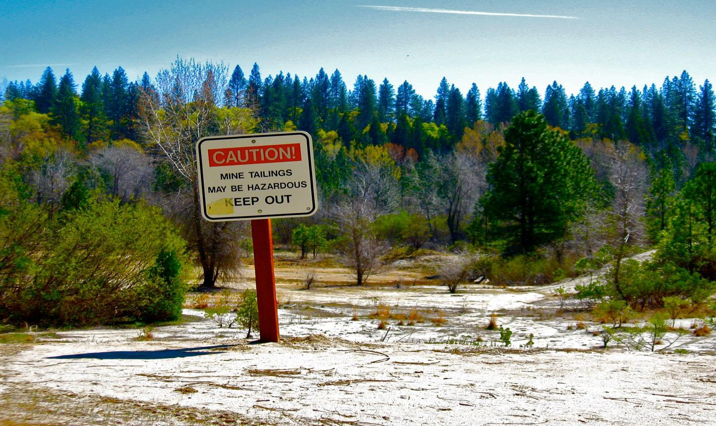 Abandoned Mine Land with sign warning about mine tailing hazards